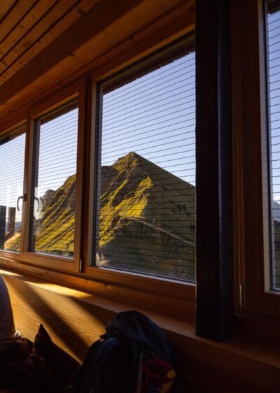 Innenraum der Tölzer Hütte mit Sitzplätzen und Holztischen